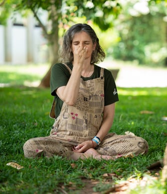 a woman sitting on the grass learning Online Yoga