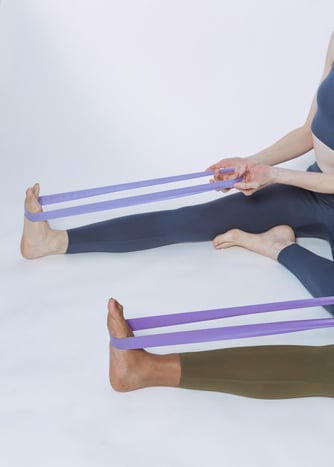 Yoga using bands to stretch legs and feet