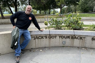 jack wozniak jeaning on a sign stating "jack's got your back"