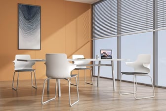 White Dora chairs around a table in a sunlit conference room with orange wall