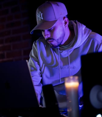 a man in a white hoodie and a white hat is sitting at a table