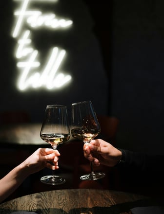 two people toasting with wine glasses