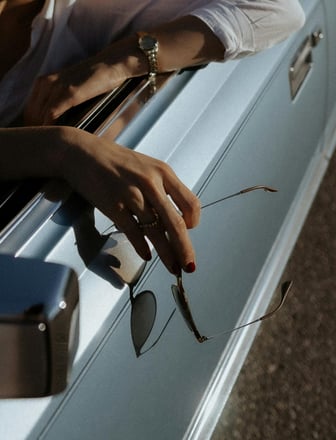 a man's hand holding a pair of glasses