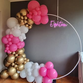 Circle hoop backdrop with a pink white gold balloon garland and eighteen neon in Redlands.
