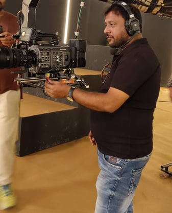 a man in a black shirt is holding a camera and a camera