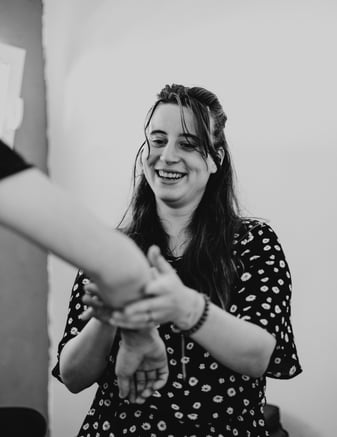 a woman holding a man's hand and smiling