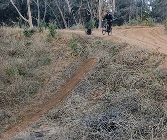 Mountain bike rider dropping into a step-down jump with a lower landing