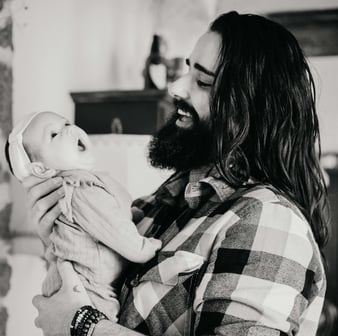 homas, photographe naissance dans le Gard, tenant sa fille dans les bras alors qu’elle baille