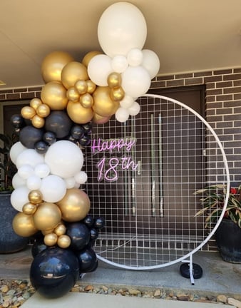 White mesh circle backdrop hired with a black white and gold balloon garland setup for 18th Birthday in Logan.