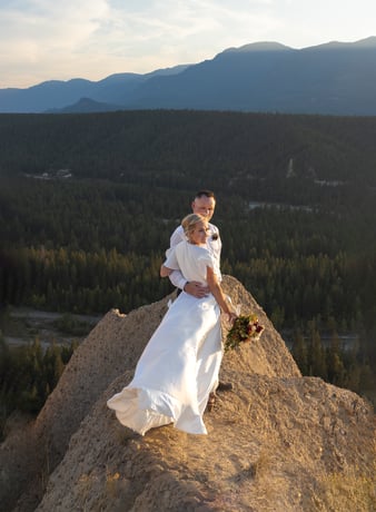 Eloping couple standing at the edge of a hoodoo