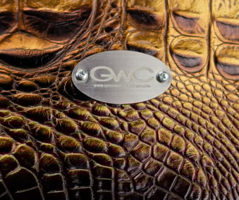 a close up of a leather bag with a metal plate with a metal plate with