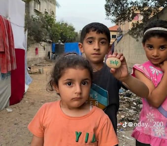 three young children standing in a dirt road