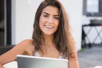 a woman sitting on a couch with a tablet computer