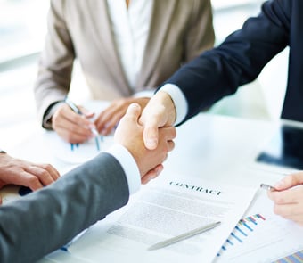 a group of people shaking hands over a table