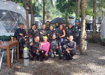 group of scuba divers, happily posing going into the dive in Dauin, Negros, the muck diving capital 