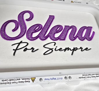 Selena Por Siempre embroidery in glittered purple and black script on white fabric – San Antonio