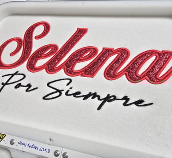 Selena Por Siempre embroidery in glittered red and black script on white fabric – San Antonio