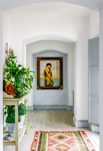Hallway with flowers, paintings and rugs at Finca Santa Katerina