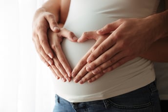 femme enceinte, mains sur le ventre en forme de coeur