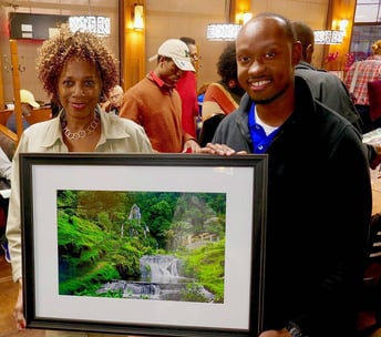 Photographer Gary Washington with collector/artist Priscilla Phifer holding Colombia Falls art.