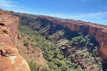 a person standing on a cliff overlooking a valley