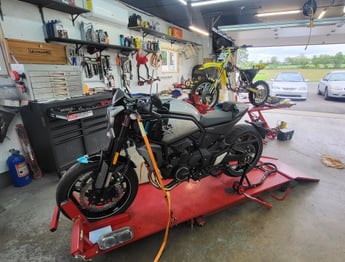 Motorcycle and dirt bike on service lifts in shop