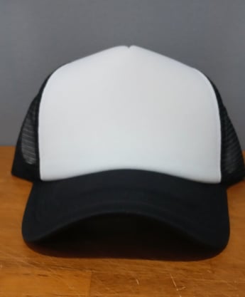 a black trucker hat with white front panel that's used for creating custom hat designs