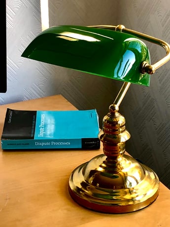 A green lamp with a book and a book on a table