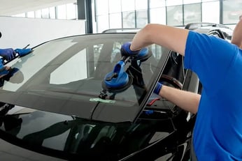 a man in a blue shirt is cleaning a car
