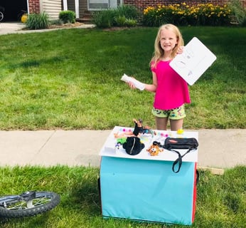 baylor holding an open sign for her yard sale