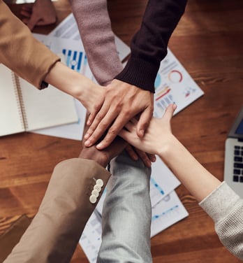 a group of people holding hands together in a circle