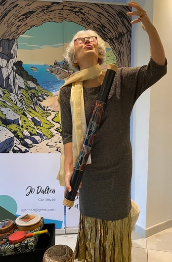 Jo Daltea conteuse devant son décor et un bâton de pluie