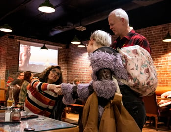 Two women shake hands as they are being introduced at a cozy restaurant during a networking event