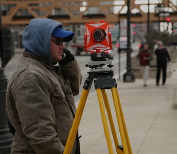 a man in a blue jacket and a camera on a tripod