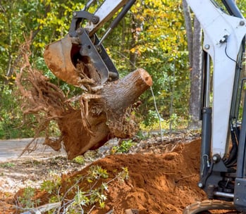 a man is taking a break from a tree stump removal