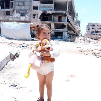 a young girl holding a stuffed animal toy