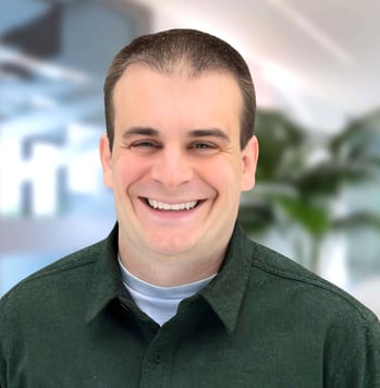 a man in a green shirt smiling at the camera