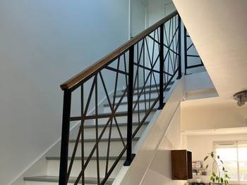 a staircase with a metal railing and a glass railing