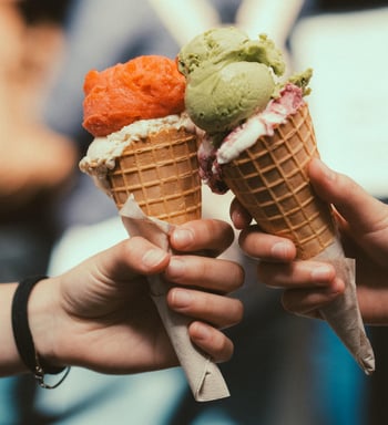 two ice cream cones one strawberry and one pistachio