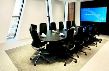 Modern meeting room with black mesh chairs and presentation screen