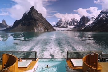 a person swimming in a pool in the mountains
