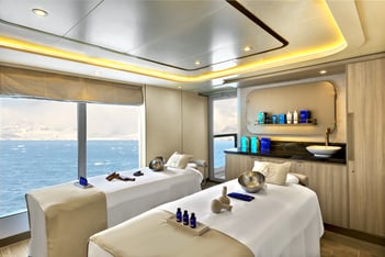 a couple of people sitting in a room with a view of the ocean