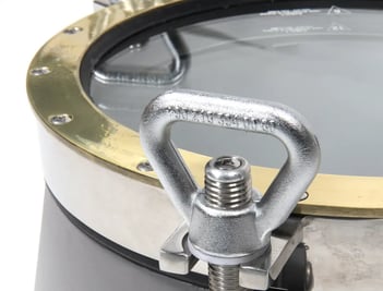 Gros plan sur un hublot inox et laiton