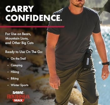 Man hiking in river with bear spray holstered. 