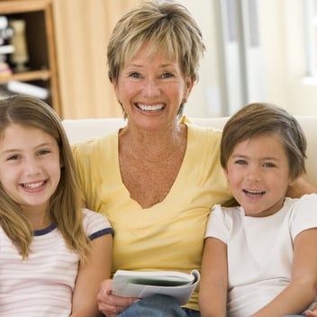 a woman sitting on a couch with two children