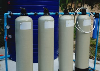 Four pressure tanks connected to water line.