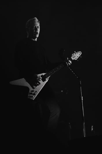 James Hetfield playing a guitar in a dark room