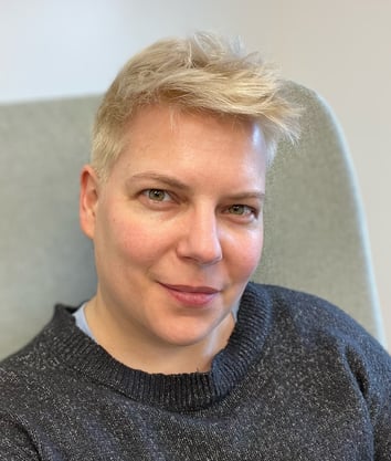 Portrait of a woman with short bleached hair and a blue sweater