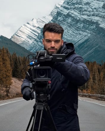 Vidéaste professionnel de Mirai Production lyon en tournage, capturant un paysage montagneux