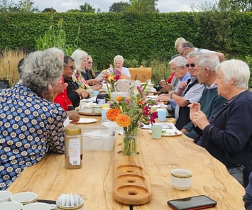 a group of people sitting at a table with coffee and tea at chiswick house